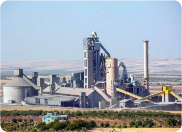 Large cement manufacturing plant with preheater tower and processing facilities.